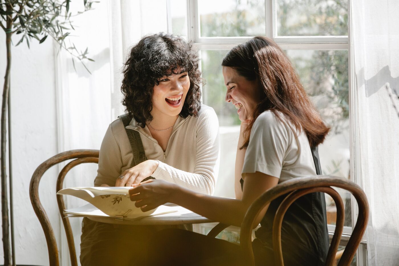 Two colleagues laughing together at a table — a shared team advent calendar moment