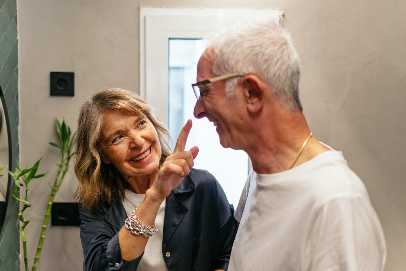 Grandparents laughing together over a phone — opening their family's digital advent calendar